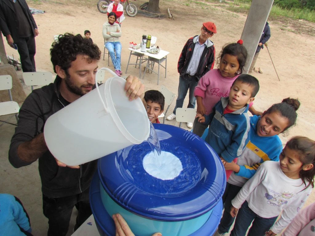 Nicolás Wertheimer enseñando a niños de una comunidad el funcionamiento de un filtro de agua.