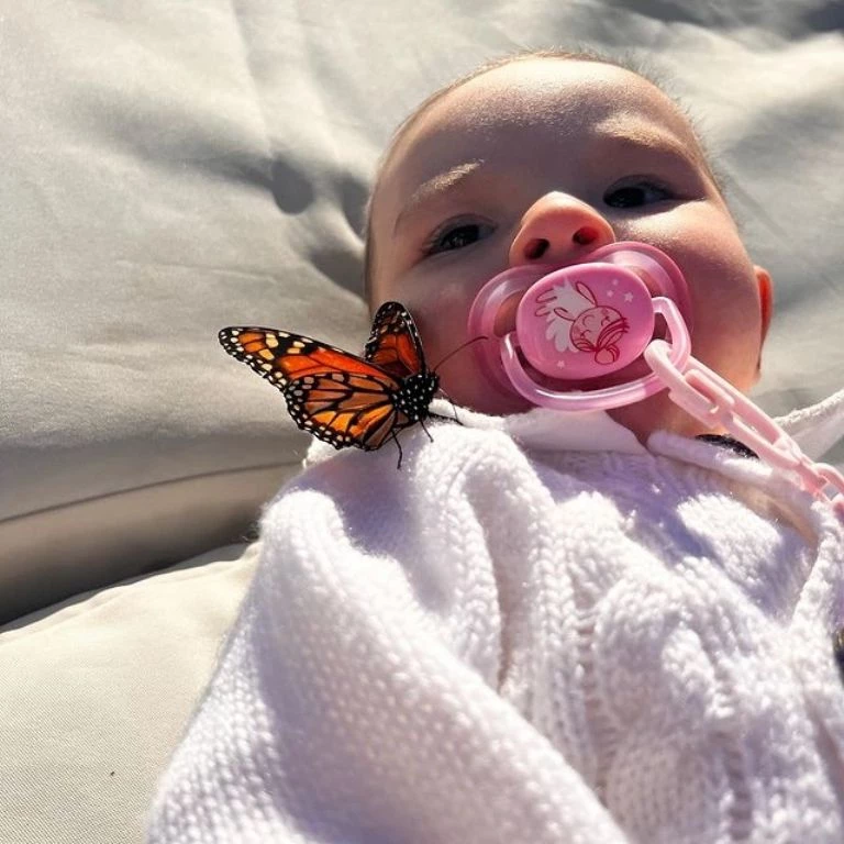 Una mariposa se posó en el hombro de Sarah Burlando. Foto redes sociales. 